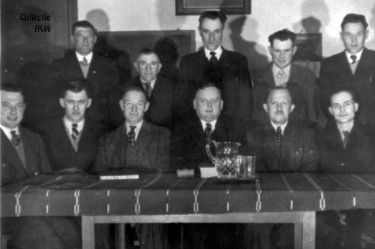 De kerkenraad van de Gereformeerde kerk. Zittend v.l.n.r. L. van Belzen, N.J. Elenbaas, Joos Tramper, ds. Veldhuijzen, Jac. Baaijens, K.J. Steketee en K. Sanderse. Staand v.l.n.r. Jan Tramper, D. Janse, Jac. de Ridder, J. Kwekkeboom en L. Baaijens.